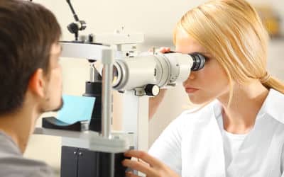 אופטימטריסטית מבצעת בדיקת ראייה לבחור צעיר באמצעות ציוד לבדיקת ראייה